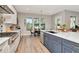 Kitchen and dining area with stainless steel appliances, white countertops, a blue island, and views to the backyard at 2707 W Fig St, Tampa, FL 33609