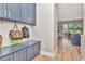 Welcoming mud room with blue cabinets, gold hardware, and convenient storage for bags and coats at 2707 W Fig St, Tampa, FL 33609