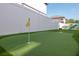 Backyard putting green with synthetic turf, a white fence, and a slide for outdoor fun at 2707 W Fig St, Tampa, FL 33609