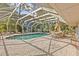 Screened-in pool features poolside loungers and dining area, perfect for relaxing or entertaining at 271 Kayli Ln, Palm Harbor, FL 34683
