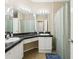 Well-lit bathroom featuring dual sinks, a vanity area, and tile flooring at 2757 Via Cipriani # 1121B, Clearwater, FL 33764