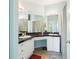 Bright bathroom features double sinks with white cabinets and black countertops at 2757 Via Cipriani # 1121B, Clearwater, FL 33764