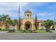 Community clubhouse features a tile roof, lush landscaping and a welcoming entrance at 2757 Via Cipriani # 1121B, Clearwater, FL 33764