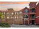 Beautiful condo exterior with private garages and colorful facade at sunset at 2757 Via Cipriani # 1121B, Clearwater, FL 33764