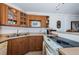 Cozy kitchen featuring wood cabinetry, stainless steel sink, and white appliances at 3315 58Th S Ave # 509, St Petersburg, FL 33711