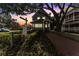 Charming two-story building with brick walkway, lush greenery, and mature trees offering a welcoming entrance at dusk at 337 S Plant Ave, Tampa, FL 33606