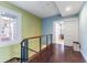 Upstairs hallway with hardwood floors, a modern railing, and a sunlit window at 337 S Plant Ave, Tampa, FL 33606