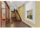 Inviting hallway features hardwood floors, a wooden staircase, and a light-filled window at 337 S Plant Ave, Tampa, FL 33606