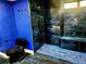 Modern bathroom featuring a sleek black toilet, glass-enclosed shower, and striking blue accent wall, for a stylish and fresh space at 3911 6Th W Ave, Palmetto, FL 34221