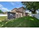 Large backyard showcasing well-maintained lawn, storage shed, mature tree, and a privacy fence at 4014 W Swann Ave, Tampa, FL 33609