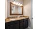Bathroom featuring double sinks with granite countertops and decorative mirror with a nice vanity light at 4014 W Swann Ave, Tampa, FL 33609