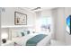 Bright bedroom with city views, a plush bed with blue accents, and a contemporary ceiling fan at 411 E Shore Drive # 205, Clearwater Beach, FL 33767