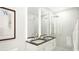Contemporary bathroom with double vanity, marble countertop, framed mirrors and sleek glass-enclosed shower at 411 E Shore Drive # 214, Clearwater Beach, FL 33767