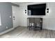 Cozy living room featuring a large TV, modern bar stools, light gray flooring, and paneled walls at 4127 Dolphin Dr # 4127, Tampa, FL 33617