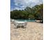 Community pool area with outdoor seating, surrounded by lush green trees and landscaping at 4127 Dolphin Dr # 4127, Tampa, FL 33617