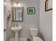 Charming half bathroom featuring a pedestal sink, framed mirror, and neutral wall color at 4710 W El Prado Blvd, Tampa, FL 33629