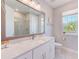 A bright bathroom features double sinks, a large mirror, and a window offering plenty of natural light at 4710 W El Prado Blvd, Tampa, FL 33629