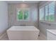 A luxurious bathroom features a modern soaking tub set against a tile wall with a window providing natural light at 4710 W El Prado Blvd, Tampa, FL 33629