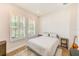 Cozy bedroom featuring a shiplap wall, wood floors, and bright natural light from windows with white shutters at 4710 W El Prado Blvd, Tampa, FL 33629