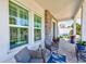 Relaxing front porch featuring comfortable seating with stone accents, a rug, and potted plants at 4710 W El Prado Blvd, Tampa, FL 33629