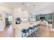 Bright open kitchen with white cabinets, marble countertops, an island with seating, and stainless steel appliances at 4710 W El Prado Blvd, Tampa, FL 33629