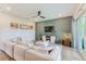 Bright and inviting living room with green paneled wall, large sofa and sliding glass doors at 4710 W El Prado Blvd, Tampa, FL 33629