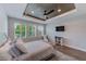 Bright main bedroom featuring a tray ceiling, wood floors, and ample natural light at 4710 W El Prado Blvd, Tampa, FL 33629