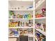 A well-stocked pantry with white shelves filled with a variety of food items and household goods at 4710 W El Prado Blvd, Tampa, FL 33629