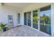 Outdoor patio featuring sliding glass doors, a ladder shelf, and neutral pavers ideal for relaxing outdoors at 4710 W El Prado Blvd, Tampa, FL 33629