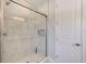 A glass-enclosed shower features tiled walls and modern fixtures, complemented by a built-in shelving niche at 4710 W El Prado Blvd, Tampa, FL 33629