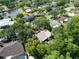 Aerial view of a single-Gathering home nestled among lush trees near a pond and other residential properties at 495 Palmdale Dr, Oldsmar, FL 34677