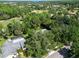 Aerial view of a home surrounded by lush trees, and a well-maintained golf course in the distance at 495 Palmdale Dr, Oldsmar, FL 34677