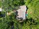 Aerial shot showcasing the house with a driveway, some yard space, and enveloped by mature trees at 495 Palmdale Dr, Oldsmar, FL 34677