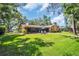 Large, verdant backyard with a screened lanai and patio seating, perfect for outdoor enjoyment at 495 Palmdale Dr, Oldsmar, FL 34677