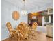Dining area with woven chairs, glass table, and views of the living room with fireplace at 495 Palmdale Dr, Oldsmar, FL 34677