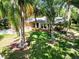 Well-maintained front yard showcases mature trees, vibrant landscaping, and a welcoming facade at 495 Palmdale Dr, Oldsmar, FL 34677