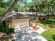 Overhead shot of a home's landscaped front yard leading to an attached two car garage with a palm tree focal point at 495 Palmdale Dr, Oldsmar, FL 34677