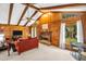 Inviting living room featuring wood paneled walls, a brick fireplace, and beamed ceilings at 495 Palmdale Dr, Oldsmar, FL 34677