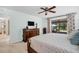 Main bedroom featuring wood furniture, a ceiling fan and a bright window with garden view at 495 Palmdale Dr, Oldsmar, FL 34677
