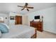This main bedroom boasts a ceiling fan and wood dresser with mounted television at 495 Palmdale Dr, Oldsmar, FL 34677