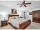 Bright main bedroom features a ceiling fan, wood furniture, and decorative wall art at 495 Palmdale Dr, Oldsmar, FL 34677