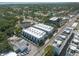An aerial view of a white three-story apartment complex surrounded by lush trees and in a bustling St. Petersburg, Florida neighborhood at 5008 S Macdill Ave # 10, Tampa, FL 33611