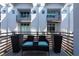 Outdoor balcony with wicker furniture, dark planters and a townhouse exterior view at 5008 S Macdill Ave # 10, Tampa, FL 33611