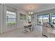 Bright dining room features white furniture, modern lighting, and sliding doors to the outdoor patio at 5814 Silver Sun Dr, Apollo Beach, FL 33572
