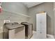 Laundry room with front-loading washer and dryer, wire shelving and a white storage cabinet at 5814 Silver Sun Dr, Apollo Beach, FL 33572
