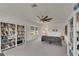 Bright living room featuring neutral walls, carpet, a large ceiling fan, and bookshelves at 5814 Silver Sun Dr, Apollo Beach, FL 33572