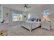 This bedroom with a view features white furnishings, coastal decor, and neutral carpeting at 5814 Silver Sun Dr, Apollo Beach, FL 33572