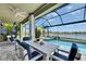 Screened patio area with dining and lounge seating that overlook the pool and water view at 5814 Silver Sun Dr, Apollo Beach, FL 33572