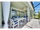 Screened in patio area with outdoor dining set, curtains and ceiling fan at 5814 Silver Sun Dr, Apollo Beach, FL 33572