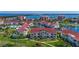 Aerial view of condos with red roofs and palm trees, with a bridge and ocean visible in the background at 6059 Bahia Del Mar Blvd # 235, St Petersburg, FL 33715